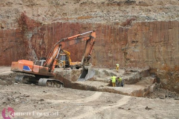 Proces pronalaženja i izvlačenja crvenog dekorativnog kamena.
